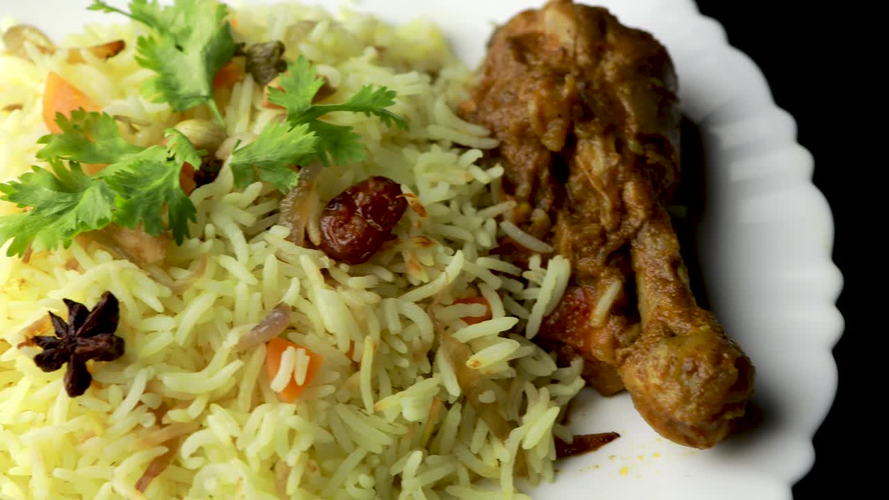 pollo biryani mostrando pedazo de pierna - es una deliciosa receta de arroz basmati mezclado con pollo marinado picante en un tazón. servido en un plato o plato. enfoque selectivo