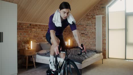 hombre trabajando en una bicicleta de ejercicio interior en casa.