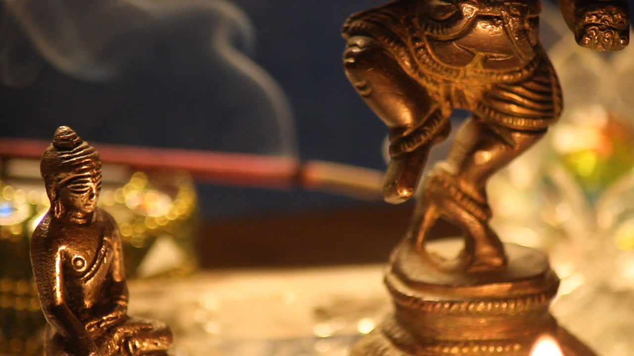 estatua de buda y ganesha meditando con velas y humo de cerca 10