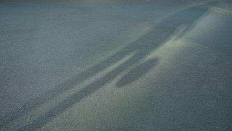 shadow of a football player on the ground during a game in a sports arena, showcasing the movement and energy of the scene as light interacts with the textured surface