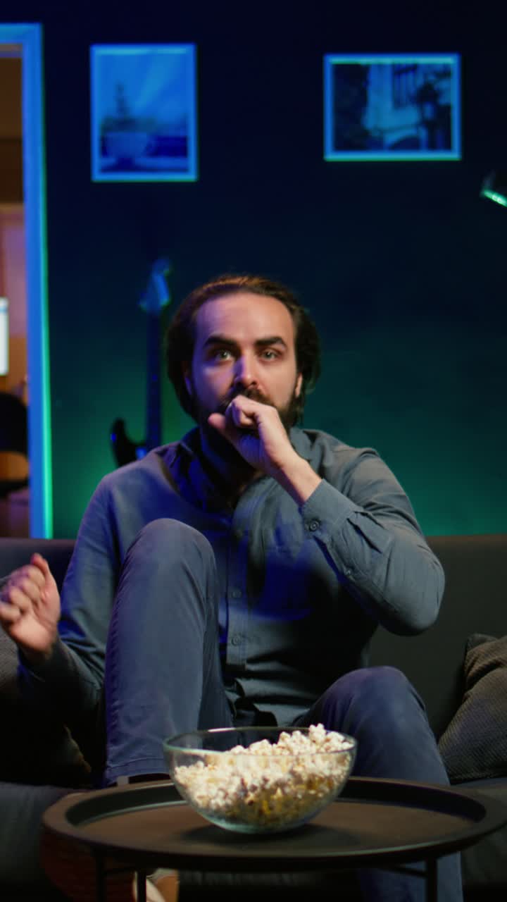 Vertical video Enraged supporter watching sports match on TV, angered by goal