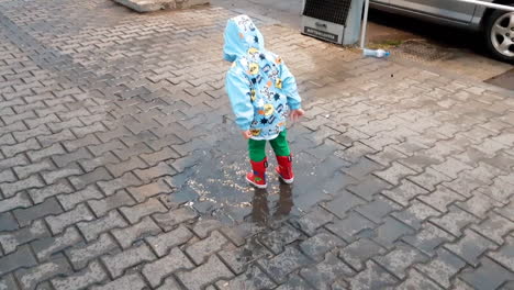 Niño-Con-Botas-De-Goma-Saltando-En-Un-Charco-En-Un-Día-Lluvioso