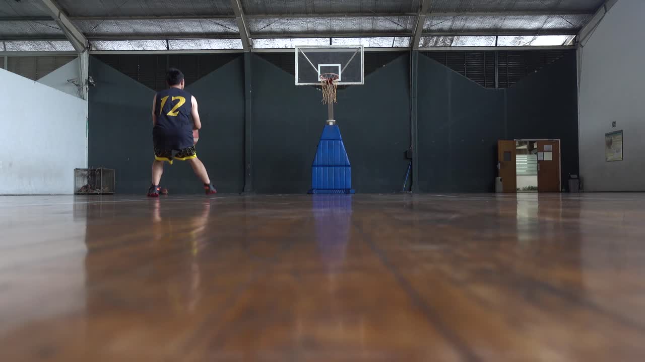 Basketball player practicing dribble and shooting at indoors court. 4K UHD