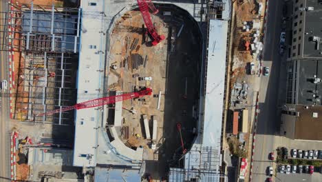 Red-Construction-Cranes-Lifting-Materials-At-The-Development-Site-Of-An-Event-Center-In-Clarksville,-Tennessee