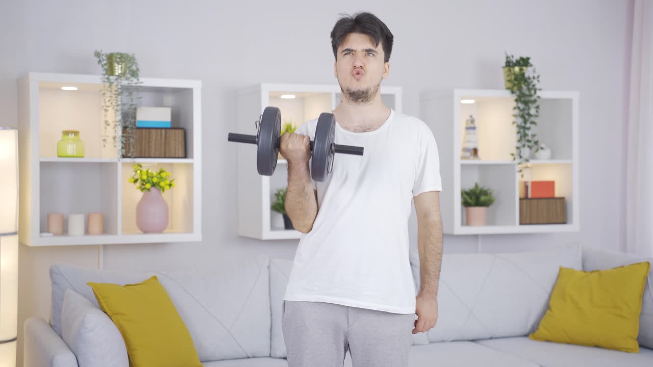 맨은 덤벨로 팔 근육을 운동합니다.