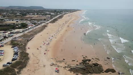 Fliegen-über-Den-Wunderschönen-Strand-Mit-Vielen-Menschen,-Die-Ihren-Urlaub-Im-Ländlichen-Spanien-Genießen