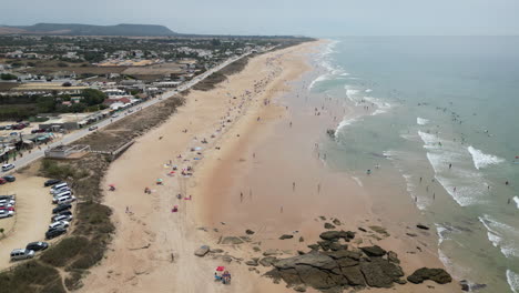 volando sobre una hermosa playa con mucha gente disfrutando de sus vacaciones en la españa rural