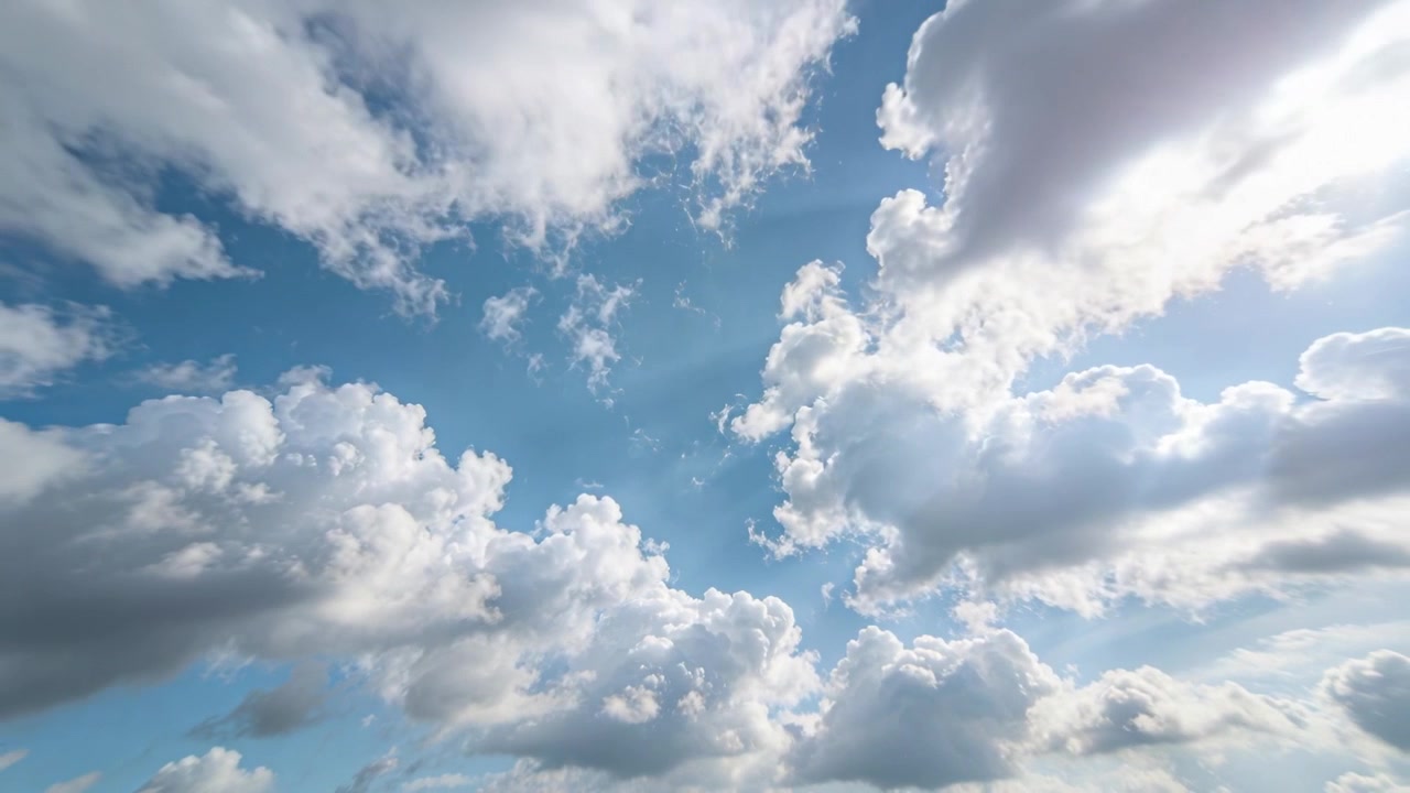 Veranderend zonlicht, drijvende stapelwolken aan de open hemel, onthullen een blauwe doorgang en zonnestralen.