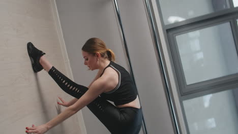 mujer estirándose en el estudio de baile