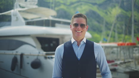 man posing in front of a yacht