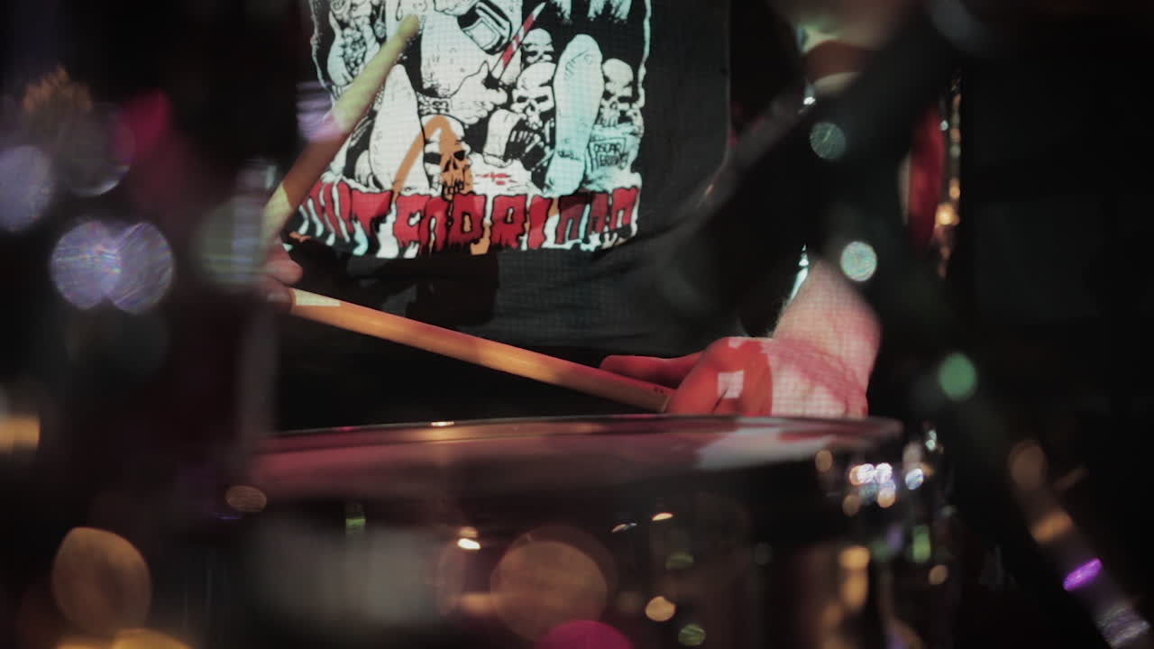 A close up of a drummer preparing to perform live on stage.