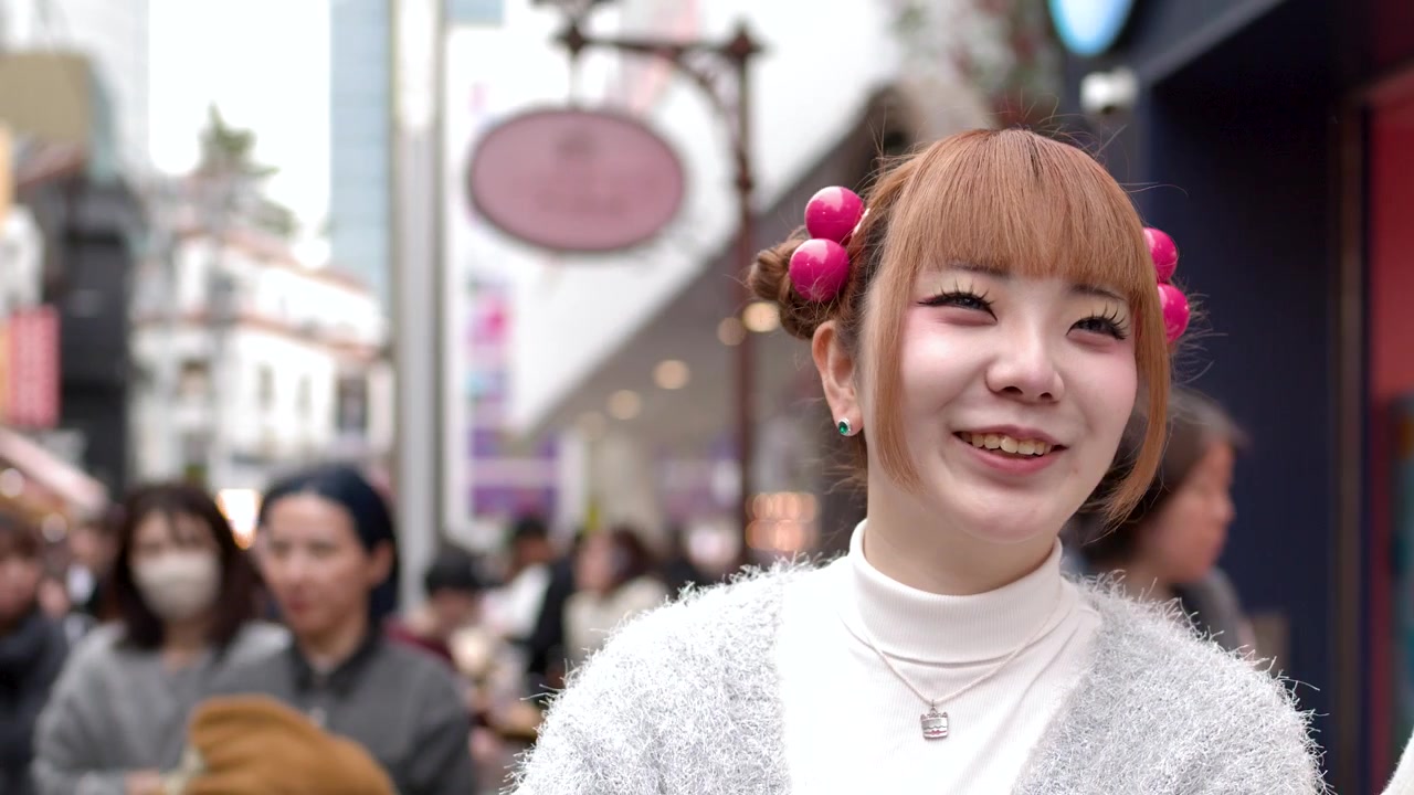 Hai cô gái trẻ Nhật Bản trò chuyện và mỉm cười trên con phố đông đúc