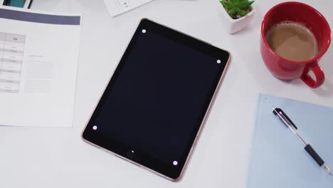 view of digital tablet and office supplies on desk at office