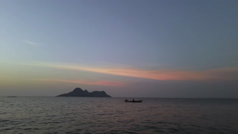 Static-shot-of-people-fishing-from-a-wooden-boat-on-Lake-Victoria-during-sunset