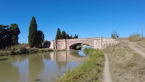 Brücke-über-Den-Canal-Du-Midi-In-Le-Somail,-Frankreich.-An-Einem-Sehr-Warmen-Sommermorgen-Führen-Fußwege-Auf-Beiden-Seiten-Des-Kanals-Zum-Touristendorf