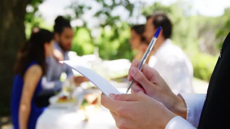 camarera escribiendo en un bloc de notas en un restaurante al aire libre