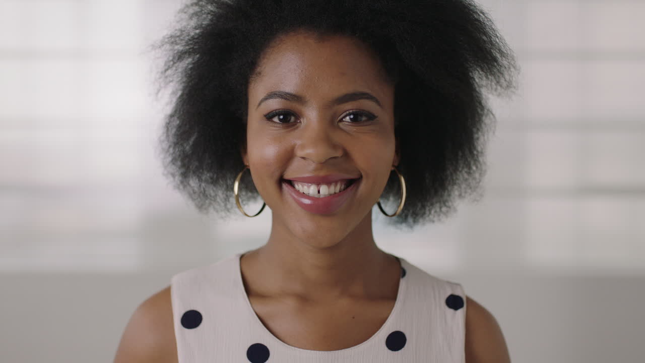 retrato de cerca de una hermosa joven afroamericana sonriendo feliz exitosa mujer negra afro peinado