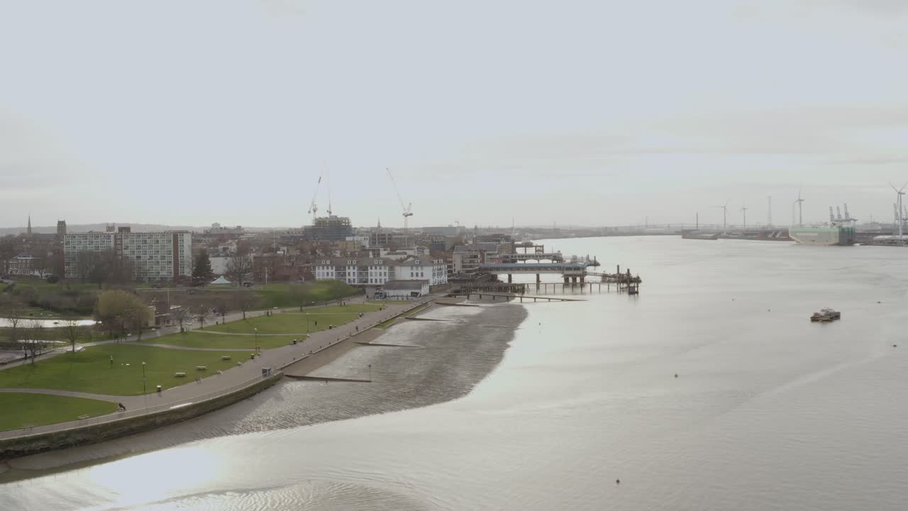 Drone flies low along River Thames shoreline near Gravesend with overcast sky
