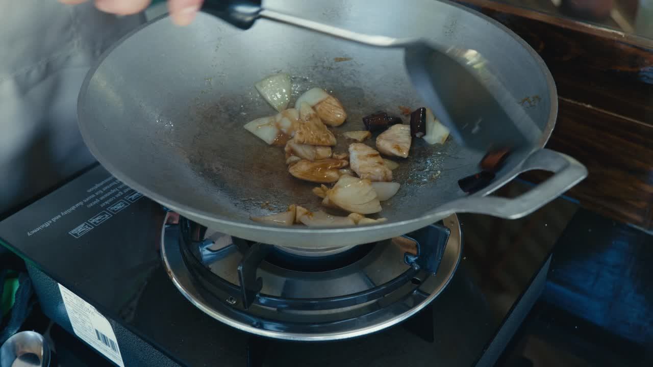 Uno chef thailandese cucina cibo tradizionale thailandese in un wok, utilizzando calore elevato e classiche tecniche di soffritto in un ambiente di cucina autentico.