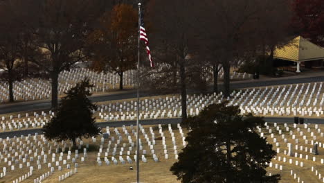 aerial lateral shot of large cemetery with american flag in fayetteville , arkansas