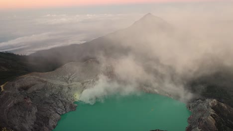 dramatic aerial view of a creator at kawah ijen volcano with turquoise sulfur lake at sunrise