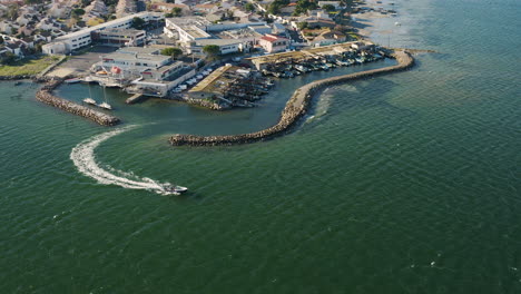 Fishing-boat-coming-out-of-the-Port-du-Barrou-in-Sète-Etang-de-Thau-aerial-drone