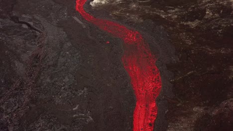 aerial view over a lava river flowing across meradalir valley, iceland, erupting out of fagradalsfjall volcano