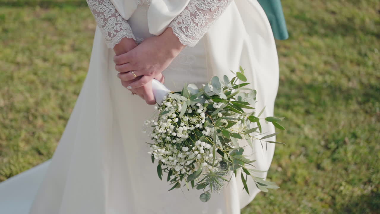 Brud med brudebuket og blondeærmedetalje