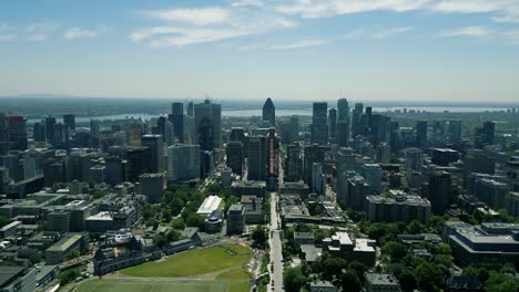 4k cinematic urban drone footage of an aerial view of buildings and skyscrapers in the middle of downtown montreal, quebec on a sunny day