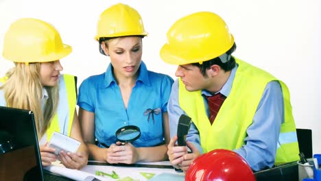 tres ingenieros atractivos trabajando con planes de construcción