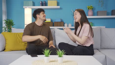 young man and young woman dance together at home and are happy.