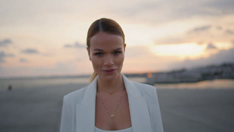 woman relaxing urban sunset looking camera with smile close up. lady walking