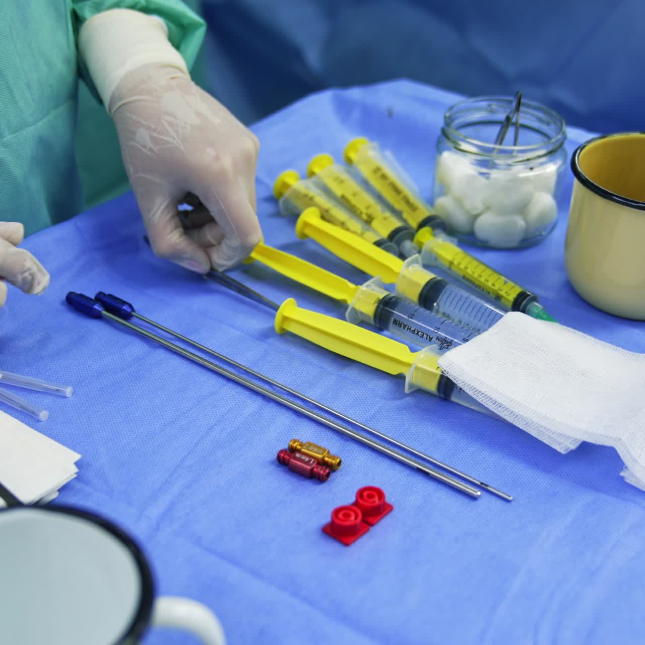 Hands of medic in latex gloves touching tools on the table. Assistant preparing instruments and materials for stem cell operation. Close up