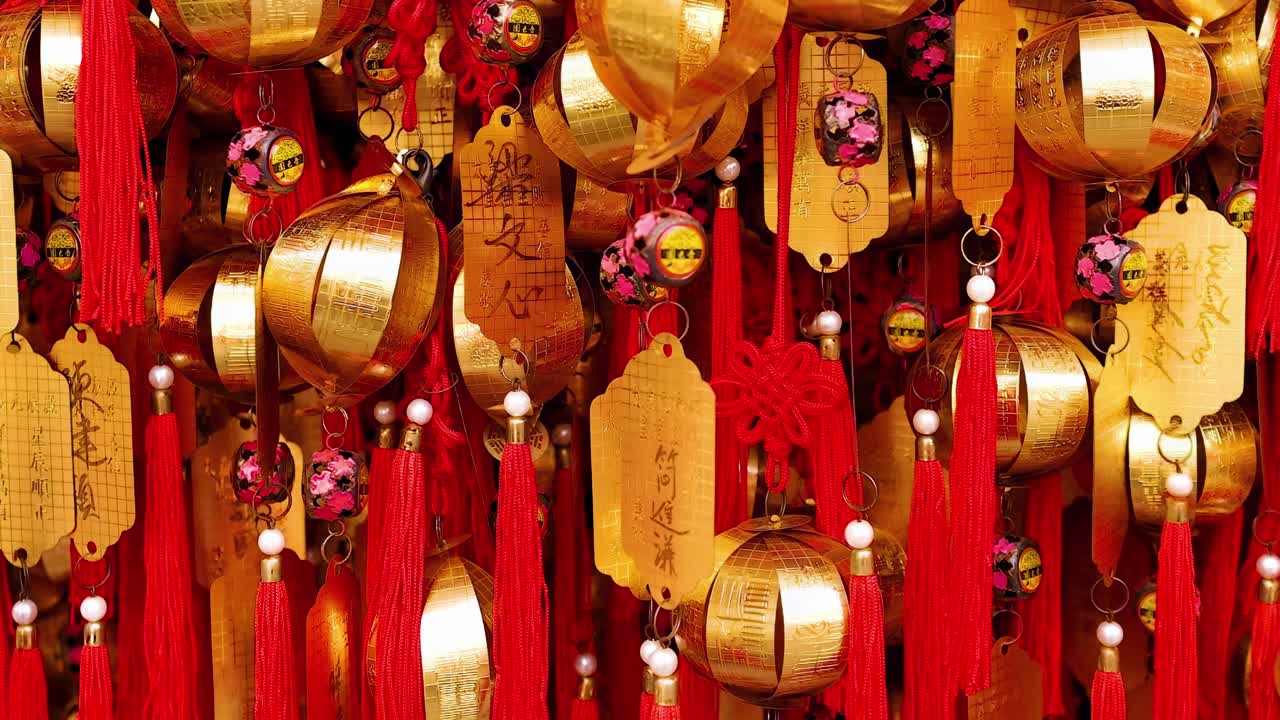 A close-up view of golden bells and red tassels, symbolizing wishes and blessings.