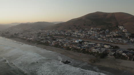 aerial view of a coastal town and beach with hillside