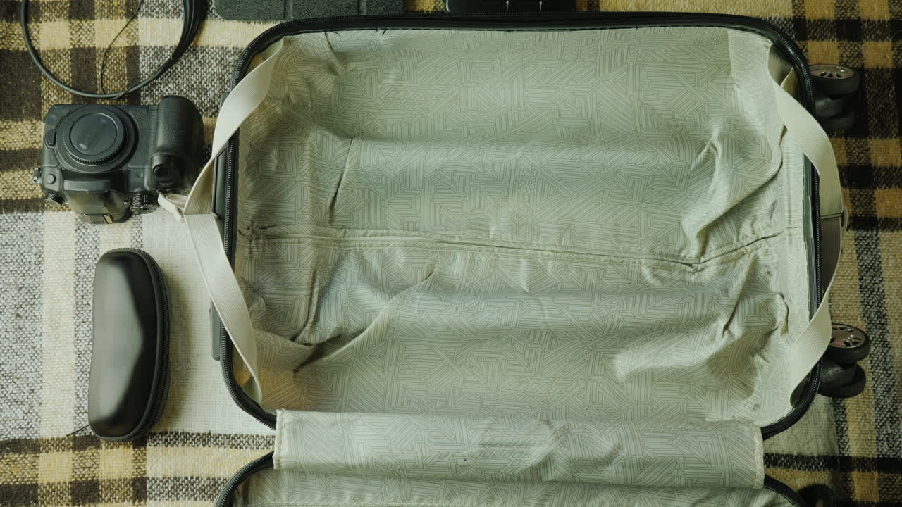 한 여성이 여행용 가방을 싸고 있다