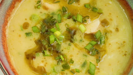 creamy yellow soup with green onions