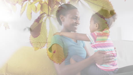 animation of happy african american mother and daughter embracing over leaves