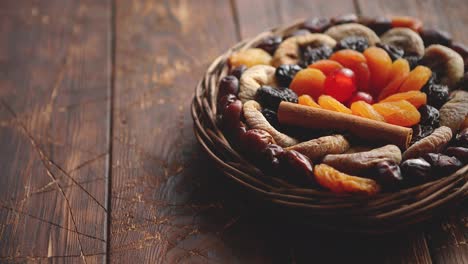 Mix-of-dried-fruits-in-a-small-wicker-basket-on-wooden-table
