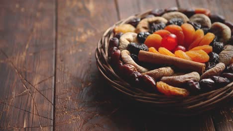 mix of dried fruits in a small wicker basket on wooden table