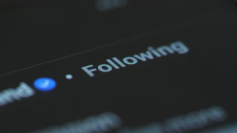 finger touching a smartphone screen to follow an account on social media