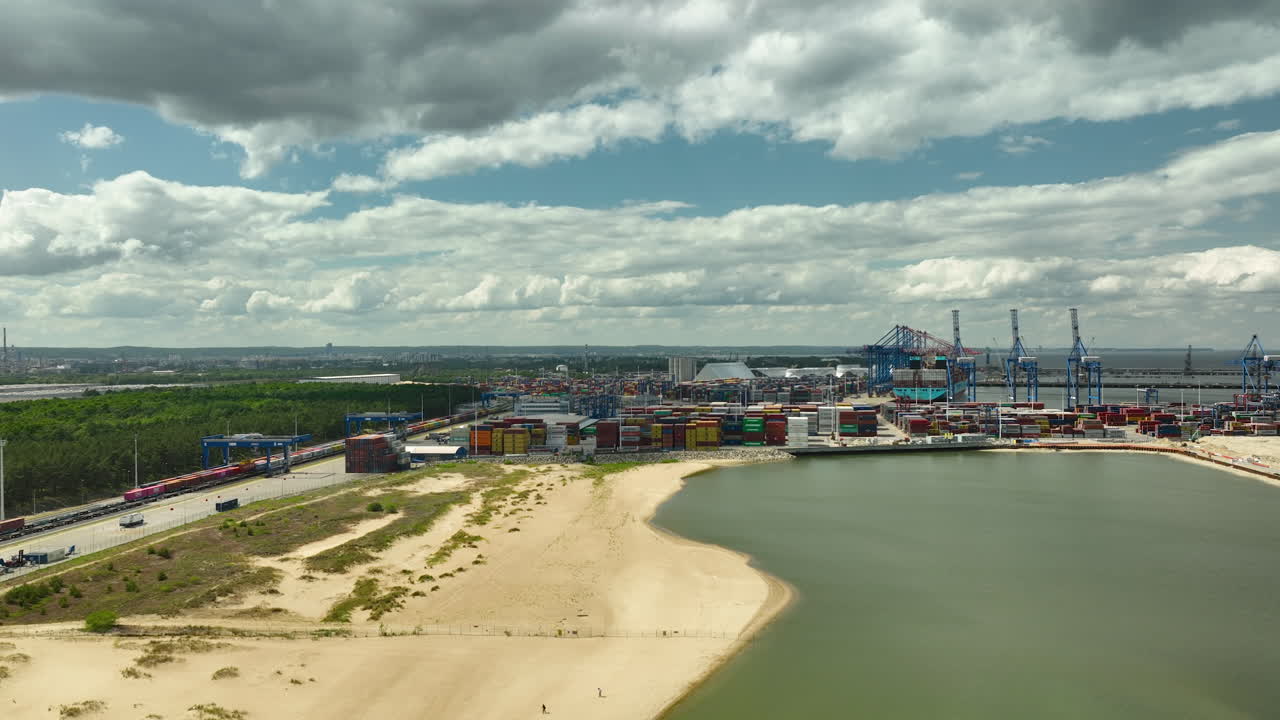 vista aérea de una zona portuaria industrial con grúas y contenedores cerca de una playa de arena - puerto principal de gdańsk - t3