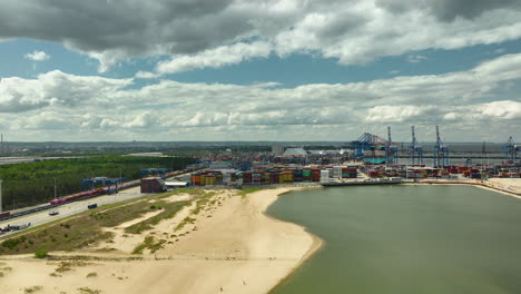 Vista-Aérea-De-Una-Zona-Portuaria-Industrial-Con-Grúas-Y-Contenedores-Cerca-De-Una-Playa-De-Arena---Puerto-Principal-De-Gdańsk---T3