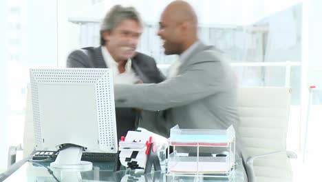 two happy businessman working at a computer