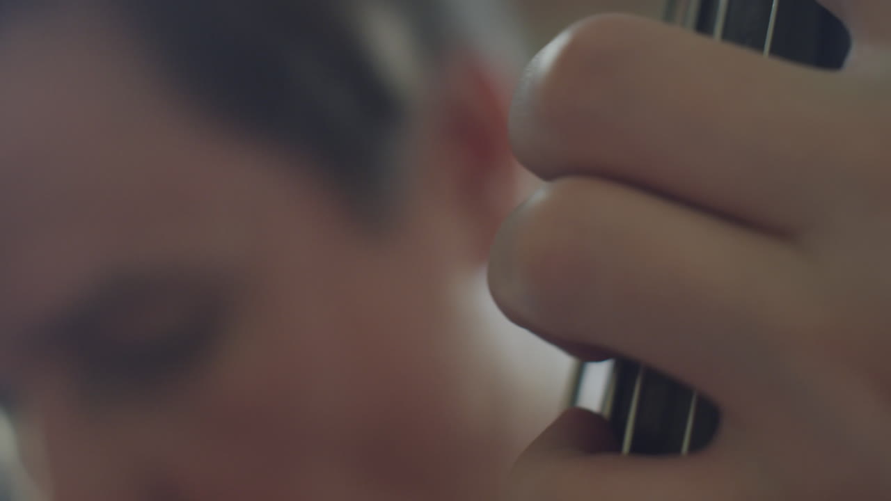 primer plano de las manos tocando una guitarra