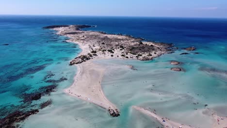 playa elafonisi en creta con aguas poco profundas que rodean la costa con cielo azul, arena rosa