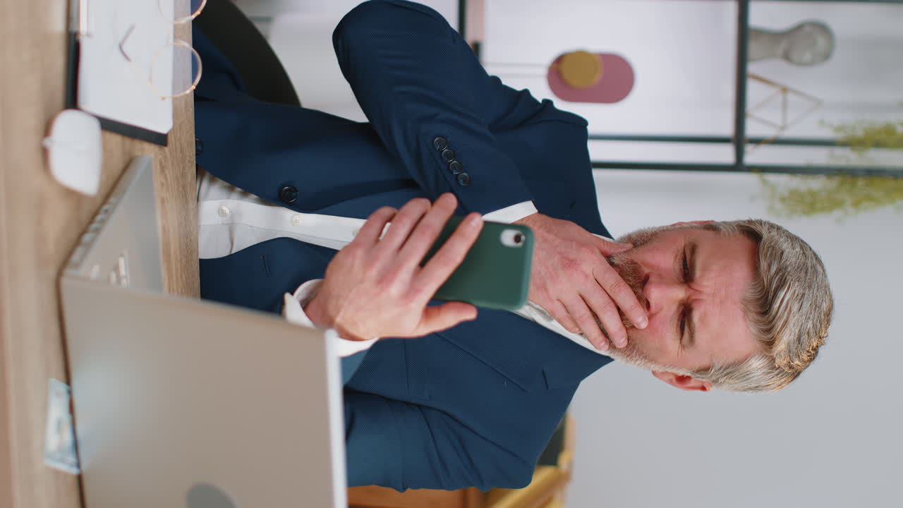 Mature old business man use smartphone surprised by bad news, fortune loss, fail, lottery results