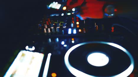 close up view of dj's hand controls on the deck at night