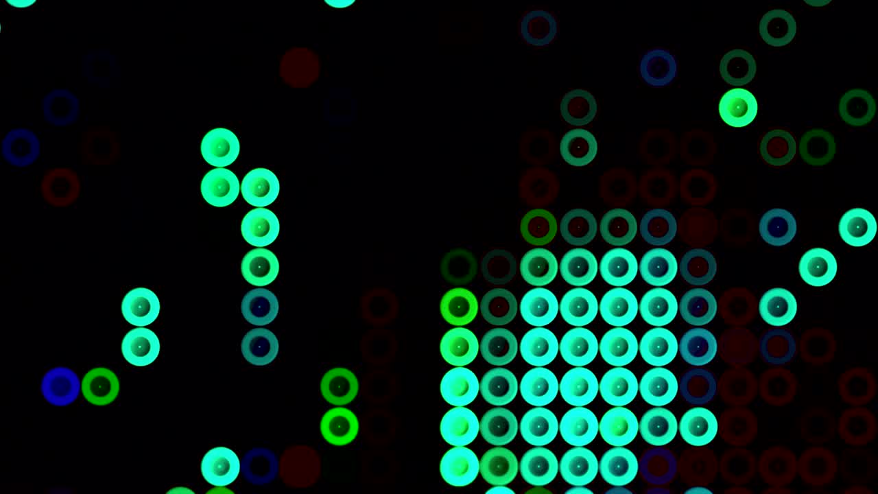 검은색 배경에 움직이는 작은 다채로운 원들이 많습니다. 모션. 순서대로 하나씩 이어지는 같은 크기의 아름다운 원들이 있습니다.
