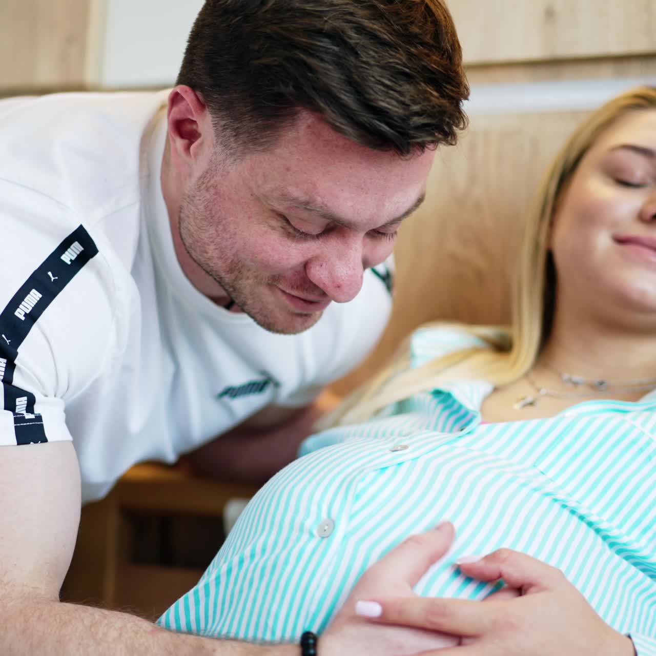 Caring husband strokes the belly of his pregnant wife. Happy parents in the maternity hospital waiting for labour